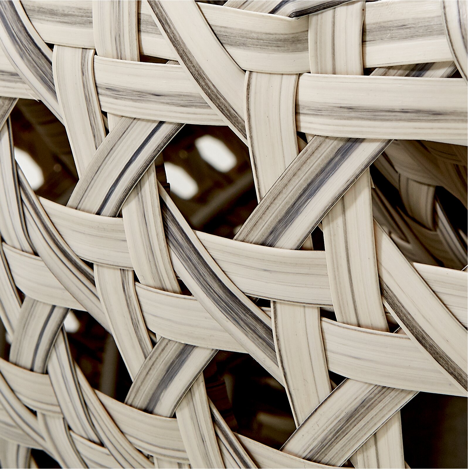 Nahaufnahme eines geflochtenen Musters aus hellen und dunklen Streifen, perspektivisch von der Seite aufgenommen.