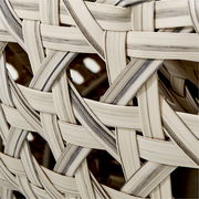 Nahaufnahme eines geflochtenen Musters aus hellen und dunklen Streifen, perspektivisch von der Seite aufgenommen.