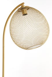 Nahaufnahme einer eleganten Stehleuchte mit einem goldenen, netzartigen Lampenschirm in seitlicher Perspektive.