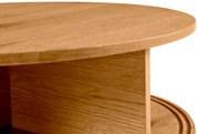 Nahaufnahme eines runden Couchtisches aus Holz mit sichtbarer Maserung, seitliche Perspektive