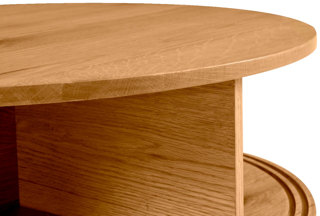 Close-up van een ronde houten salontafel met zichtbare nerf, gezien vanaf de zijkant