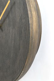 Nahaufnahme einer Holzuhr mit seitlicher Perspektive, die die Maserung und den Rand des Zifferblatts zeigt.