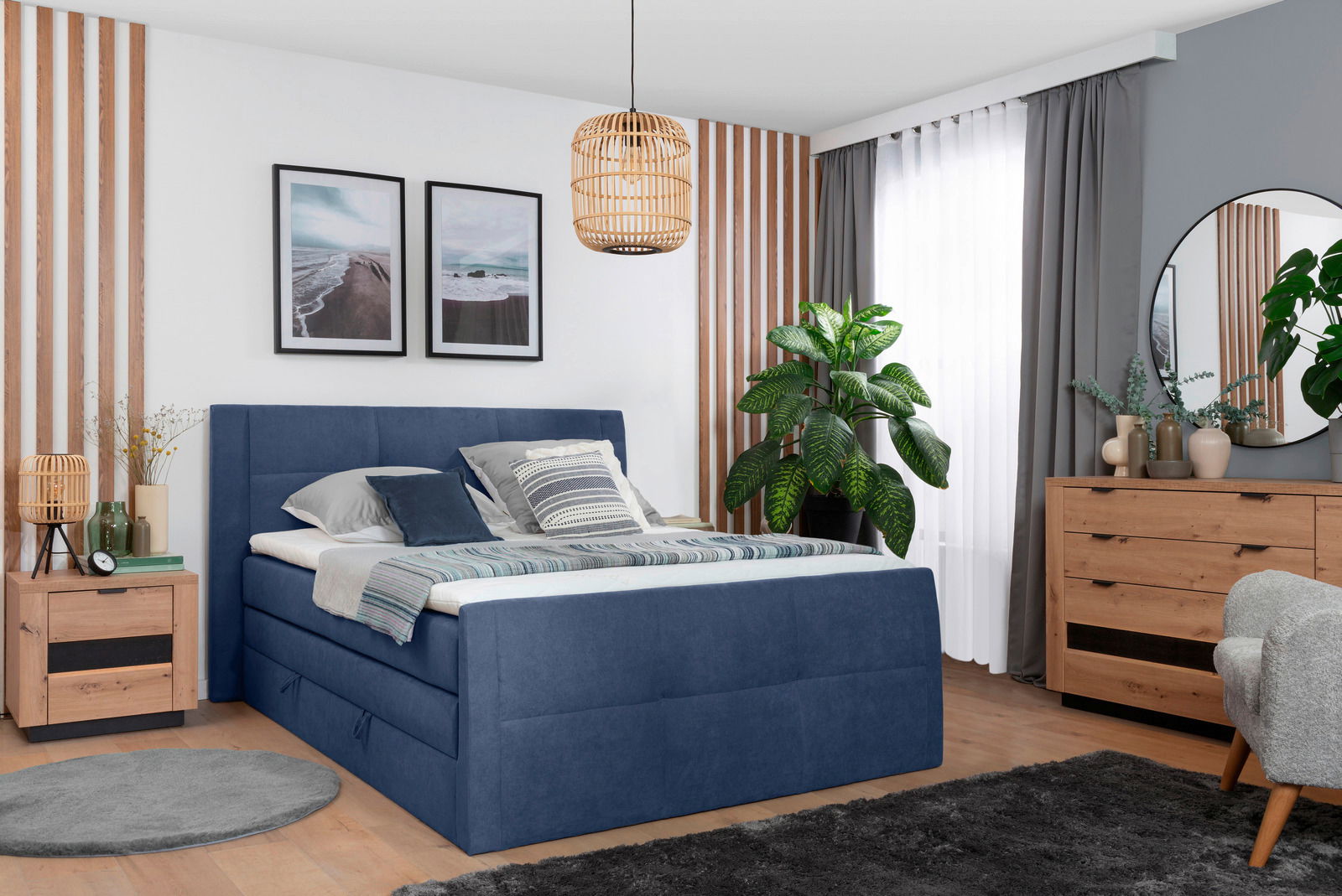 Boxspringbett 120 in einem modernen Schlafzimmer, seitliche Perspektive, mit blauer Polsterung und dekorativen Kissen.