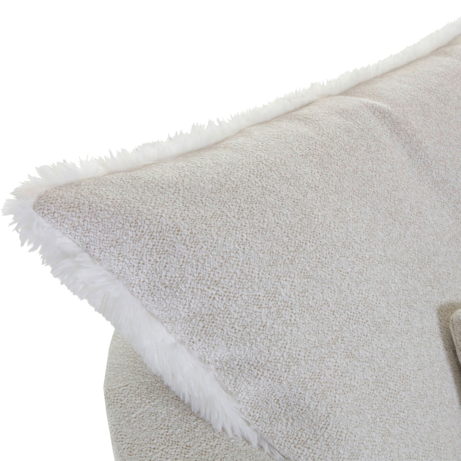 Nahaufnahme eines Sessels mit weichem, hellbeigem Stoffbezug und flauschigem Rand, seitliche Perspektive.