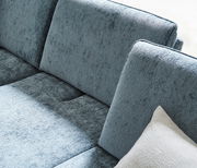 Nahaufnahme einer blauen Longchairkombination mit weicher Textur und einem weißen Kissen, seitliche Perspektive.