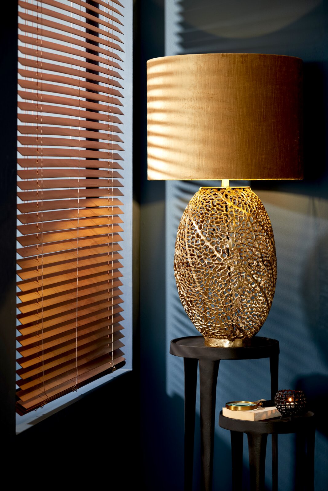 Goldener Lampenschirm Zylinder auf kunstvollem, durchbrochenem Lampenfuß, seitliche Perspektive