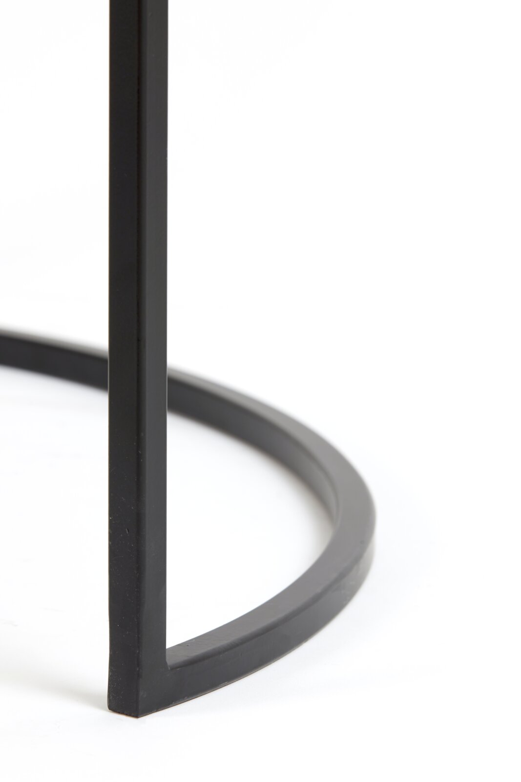 Close-up van een zwart metalen frame van een salontafel, vanuit een zijdelingse hoek gefotografeerd.