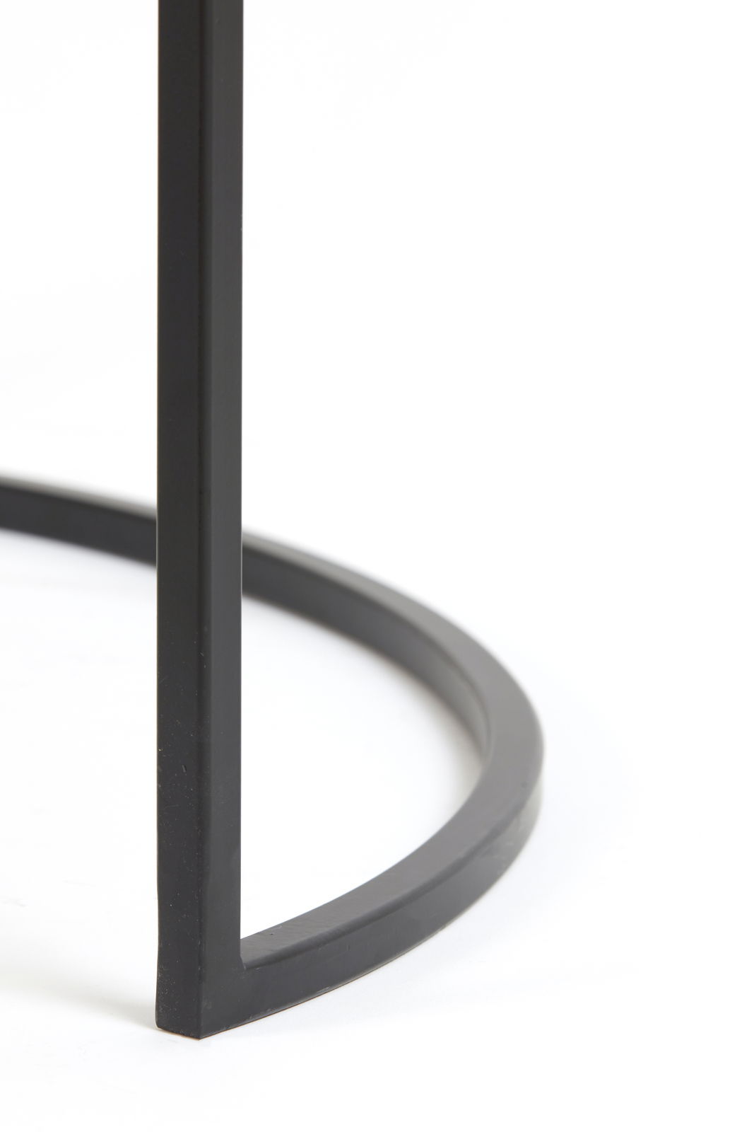 Nahaufnahme eines schwarzen Metallgestells eines Couchtisches, perspektivisch von der Seite aufgenommen.