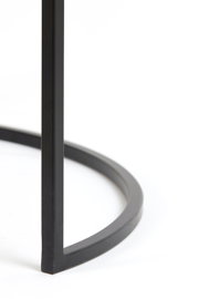 Close-up van een zwart metalen frame van een salontafel, vanuit een zijdelingse hoek gefotografeerd.
