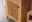 Nahaufnahme eines hölzernen Highboards mit vertikalen Lamellen und seitlicher Perspektive.