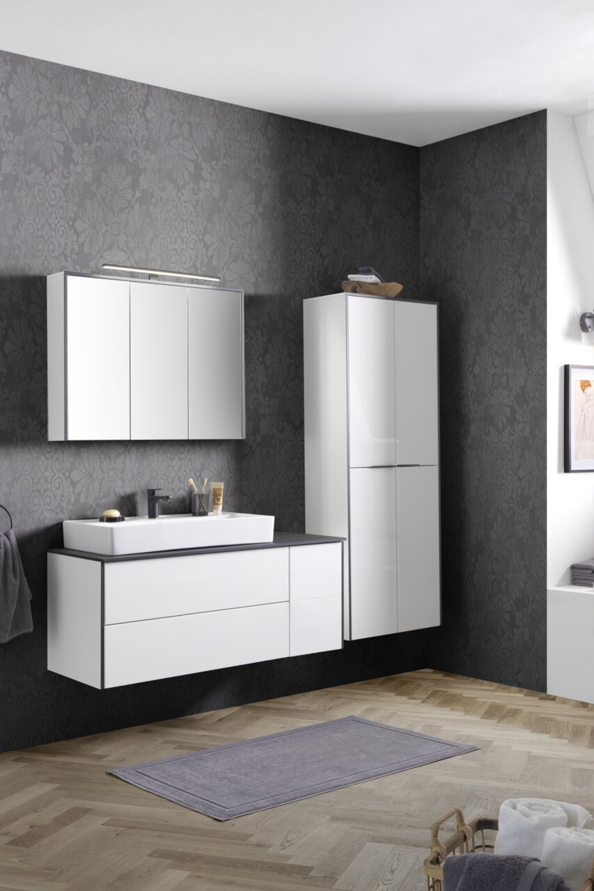 Moderne wastafelcombinatie in een stijlvolle badkamer met donker behang en een houten vloer, gezien vanuit het vooraanzicht.