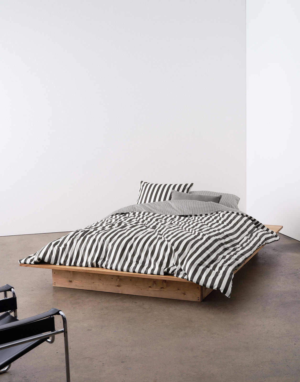 Marc O'Polo Bettwäsche CLASSIC STRIPE Bett mit gestreifter Bettwäsche in Schwarz-Weiß, auf einem niedrigen Holzrahmen, seitliche Perspektive