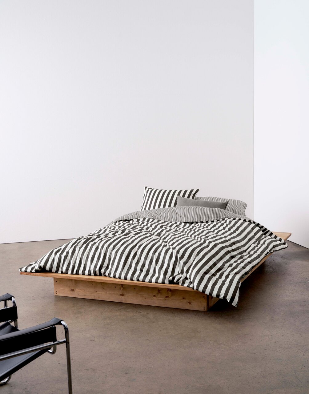 Marc O'Polo Bettwäsche CLASSIC STRIPE Bett mit gestreifter Bettwäsche in Schwarz-Weiß, auf einem niedrigen Holzrahmen, seitliche Perspektive