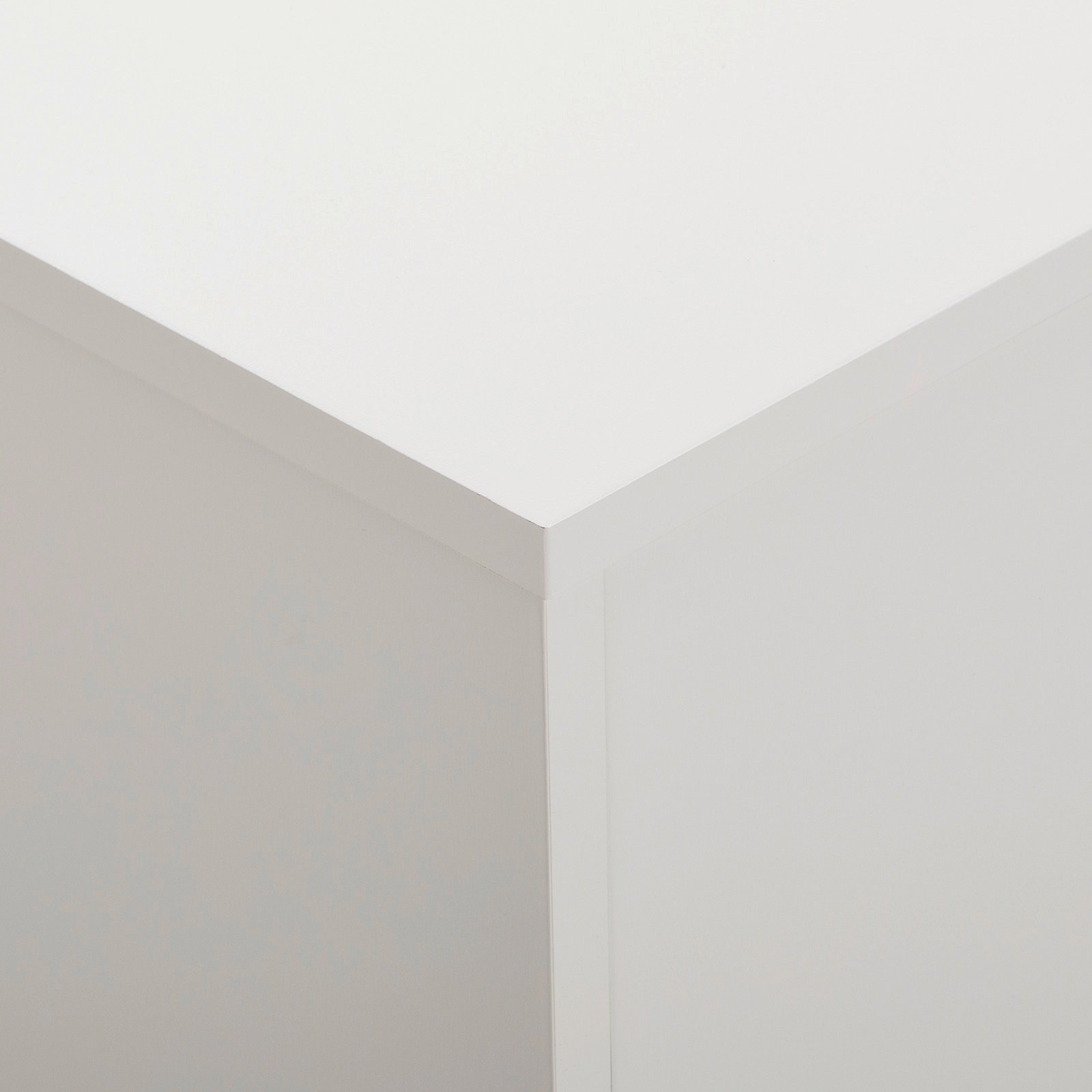 Nahaufnahme der oberen Ecke eines weißen Sideboards, Perspektive von oben.