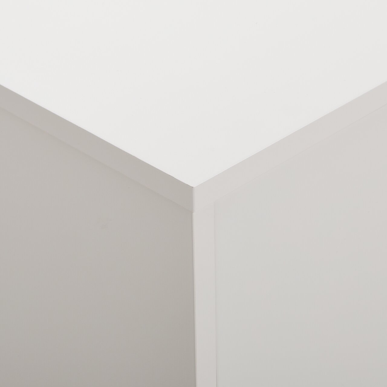 Nahaufnahme der oberen Ecke eines weißen Sideboards, Perspektive von oben.
