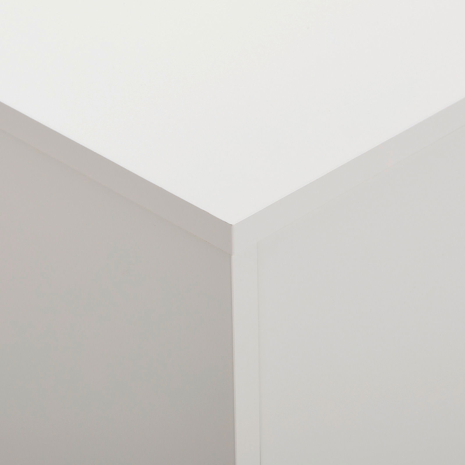 Nahaufnahme der oberen Ecke eines weißen Sideboards, Perspektive von oben.