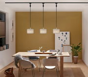 Drei moderne Pendelleuchten in einem Esszimmer, frontal betrachtet, mit einem Holztisch und weißen Stühlen darunter.