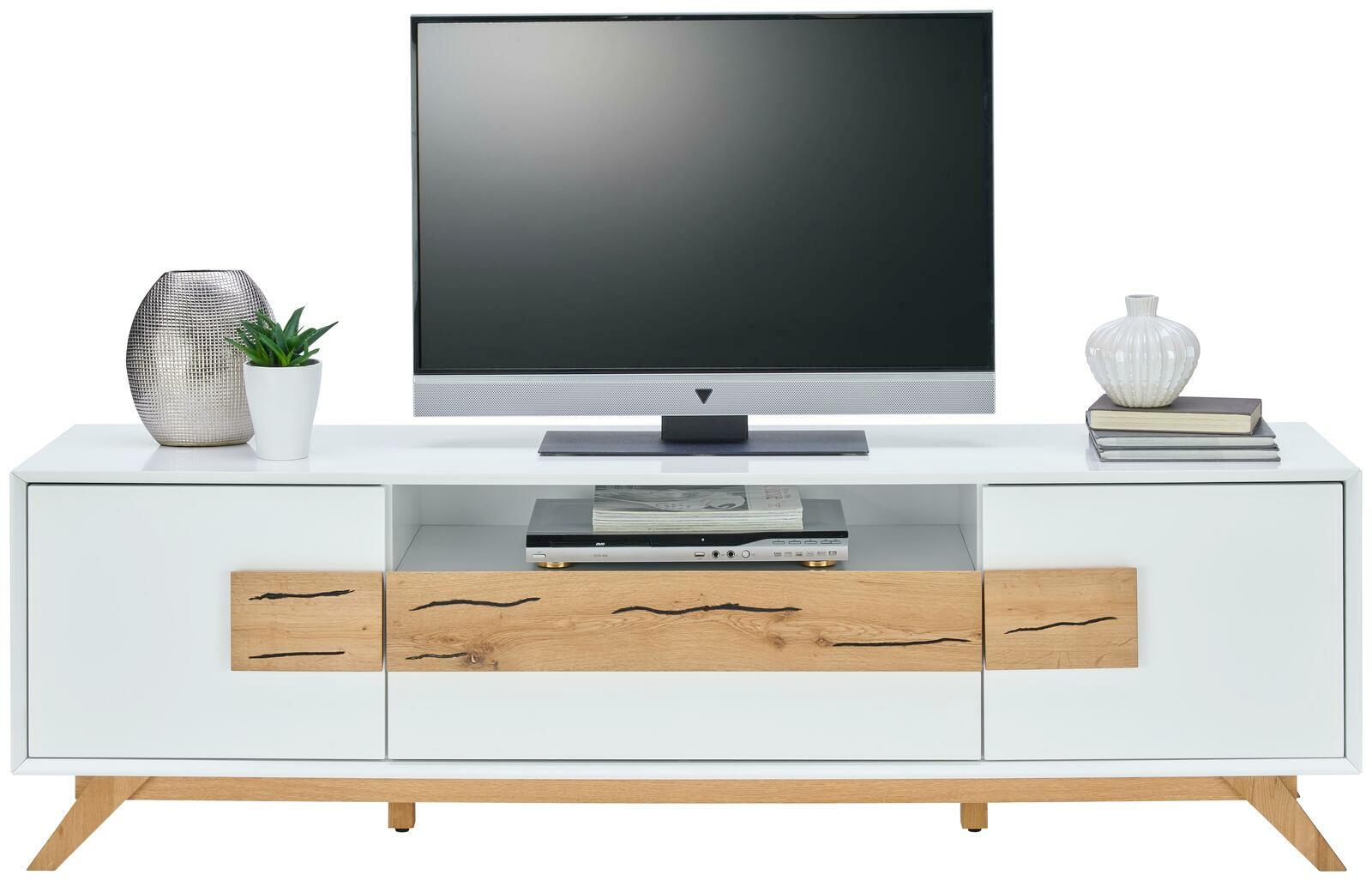 Frontale Ansicht eines modernen TV-Lowboards in Weiß mit Holzdetails, dekoriert mit Pflanzen und Büchern, und einem Fernseher darauf.
