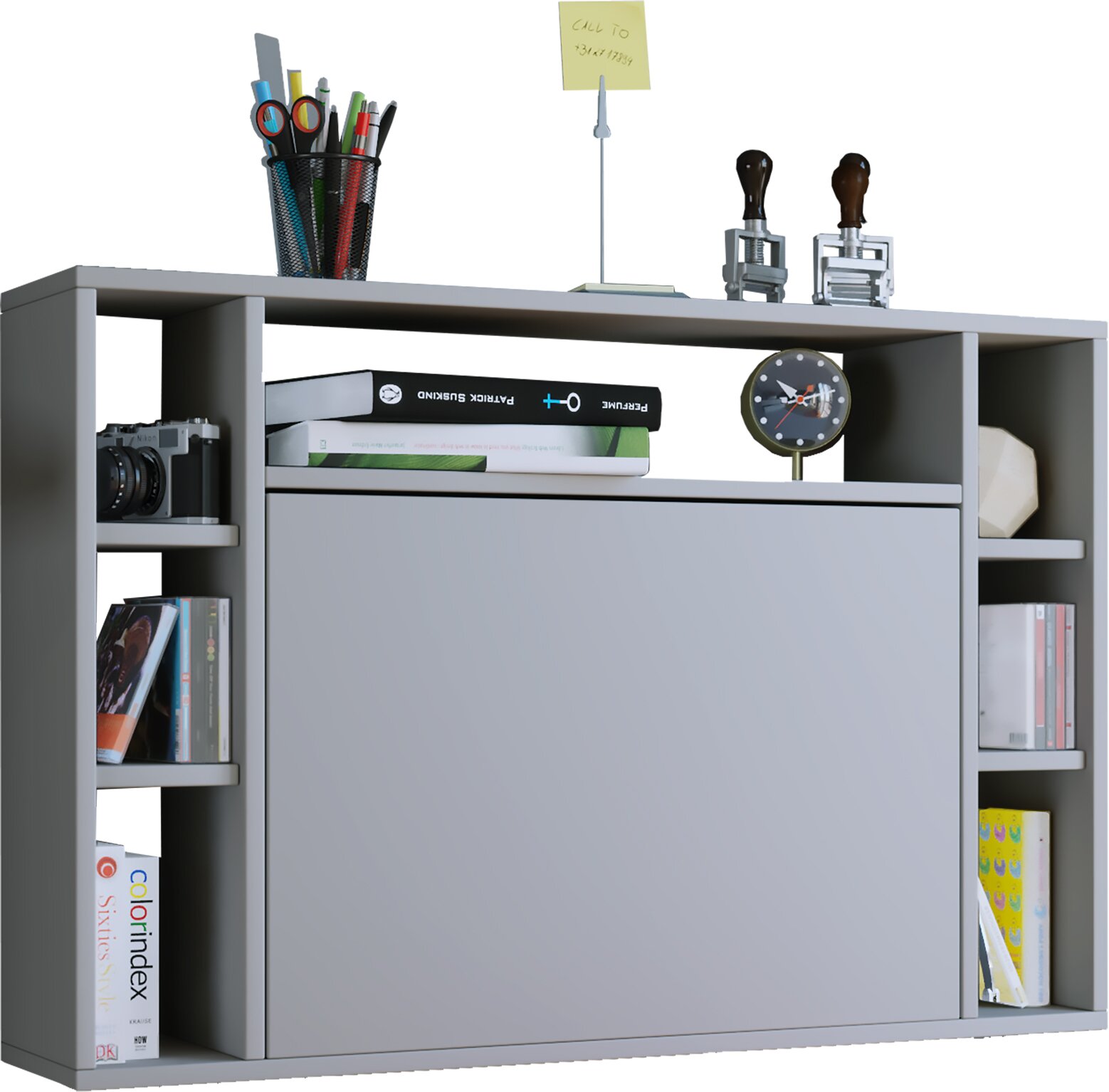 Graues Regal-/Sideboard-Element mit zentraler Schiebetür und offenen Fächern, dekoriert mit Büchern, Kamera, Stiftebecher und Uhr; Ansicht schräg von vorn leicht von oben