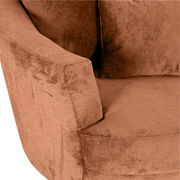 Nahaufnahme eines Sessels in warmem Braunton mit weicher Textur und Kissen, seitliche Perspektive