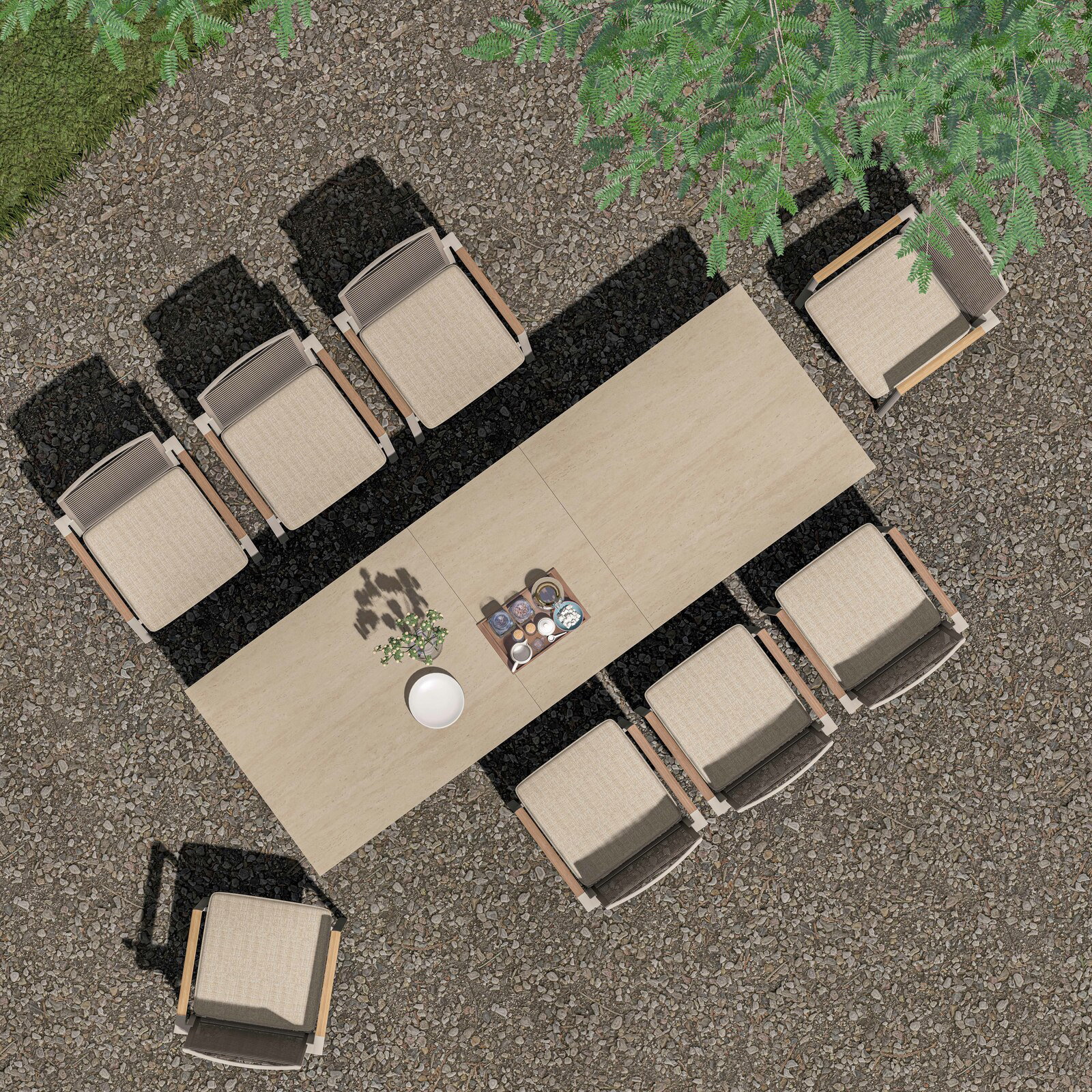 Garten Ausziehtisch mit acht Stühlen, von oben fotografiert, auf einem Kiesboden unter einem Baum.