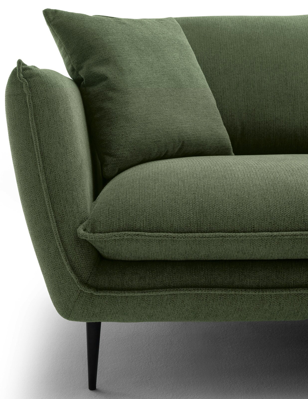 Nahaufnahme einer grünen Rundecke mit Kissen, seitliche Perspektive