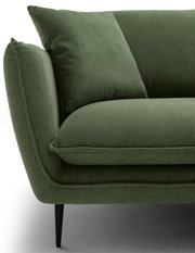 Nahaufnahme einer grünen Rundecke mit Kissen, seitliche Perspektive