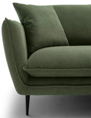 Close-up van een groene ronde hoek met kussens, zijaanzicht