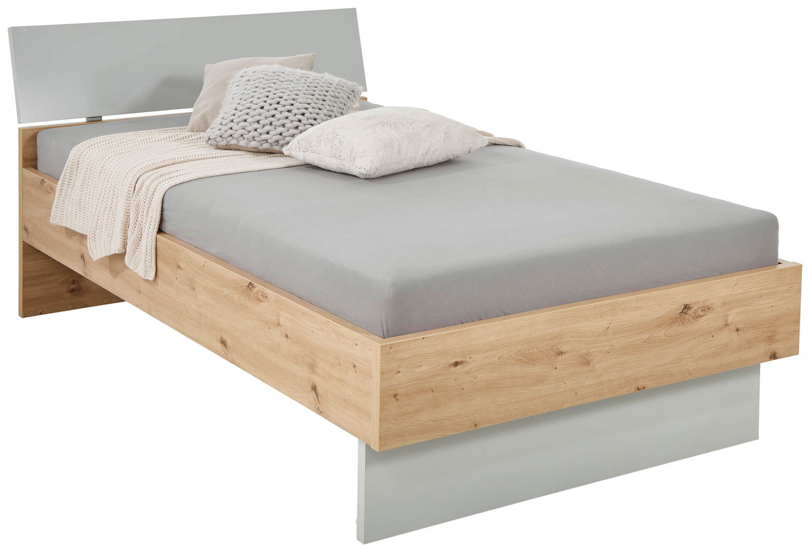 XORA Bett MALO Modernes Einzelbett aus Holz mit grauem Kopfteil, grauer Bettwäsche und dekorativen Kissen, seitliche Perspektive.