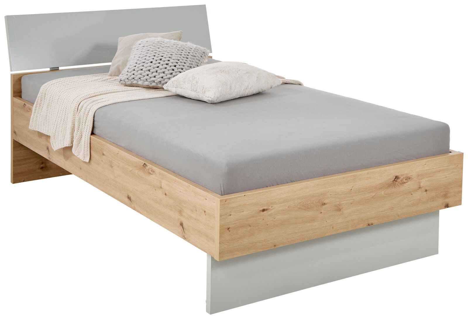XORA Bett MALO Modernes Einzelbett aus Holz mit grauem Kopfteil, grauer Bettwäsche und dekorativen Kissen, seitliche Perspektive.