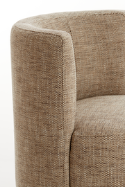 Nahaufnahme eines Sessels mit beigem Stoffbezug, seitliche Perspektive.