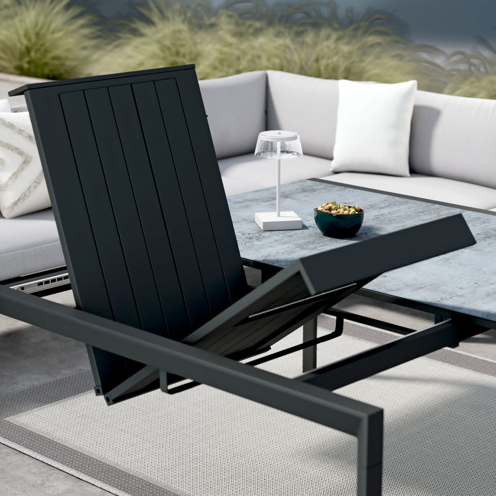 Moderner Gartentisch mit verstellbarer Tischplatte, umgeben von einem stilvollen Ecksofa, aus der Perspektive von schräg oben fotografiert.