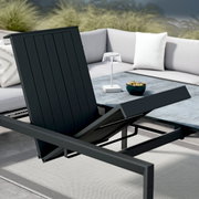 Moderner Gartentisch mit verstellbarer Tischplatte, umgeben von einem stilvollen Ecksofa, aus der Perspektive von schräg oben fotografiert.