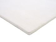 Nahaufnahme eines weißen Wollteppichs aus der Seitenperspektive