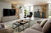 Moderner Couchtisch mit schwarzem Metallgestell und zweifarbiger Tischplatte in einem stilvoll eingerichteten Wohnzimmer, seitliche Perspektive.
