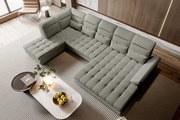 Großes hellgraues Stoff-Wohnlandschaft-Ecksofa mit gepolsterter Sitzfläche und mehreren Rückenkissen im modernen Wohnzimmer, aufgenommen aus schräger Vogelperspektive von oben.