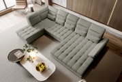 Großes hellgraues Stoff-Wohnlandschaft-Ecksofa mit gepolsterter Sitzfläche und mehreren Rückenkissen im modernen Wohnzimmer, aufgenommen aus schräger Vogelperspektive von oben.