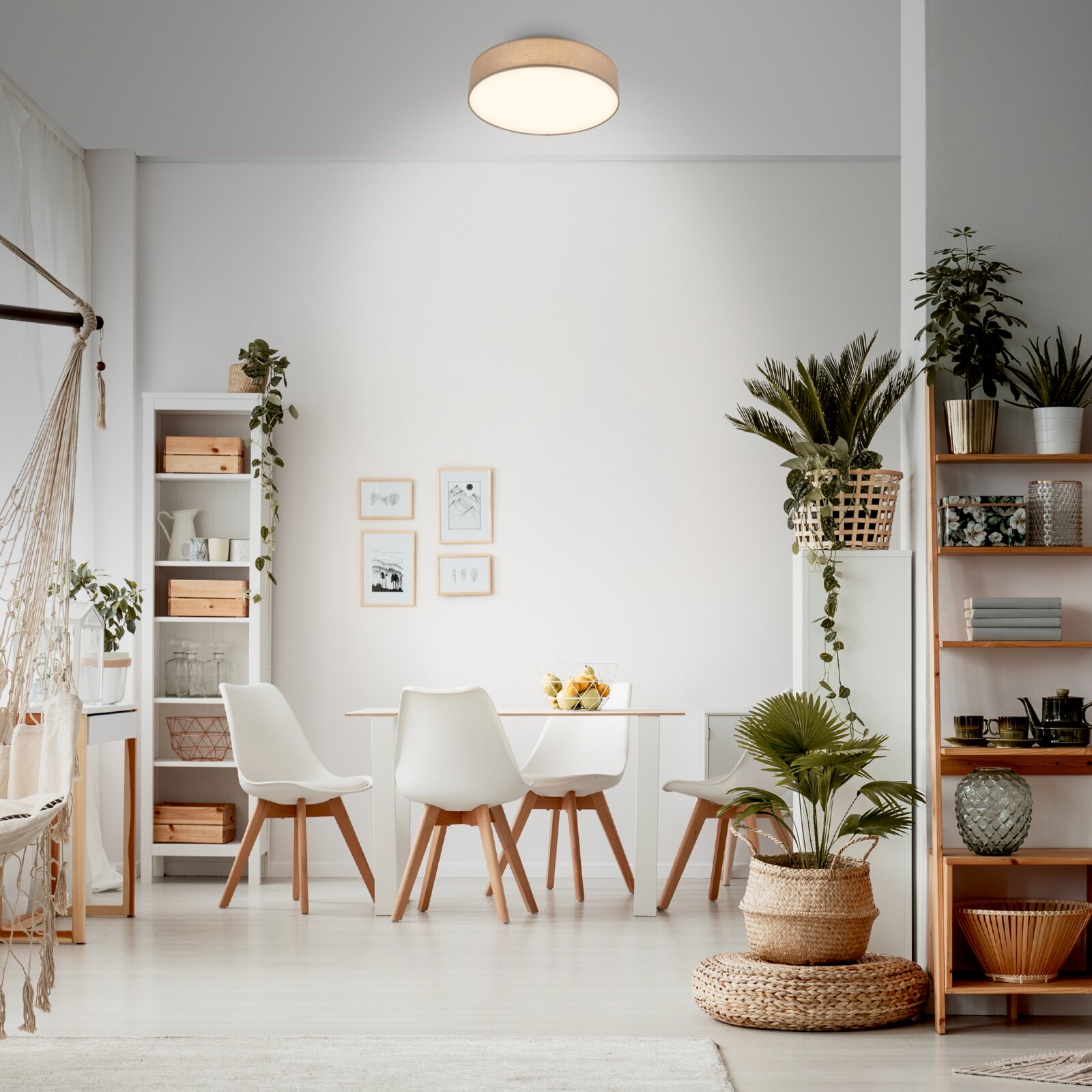 Moderne, runde LED-Deckenleuchte mit hellem Diffusor und Holzoptik-Rand, montiert an der Zimmerdecke in einem hellen Esszimmer, Perspektive: leicht nach oben aus dem Raum (Untersicht).
