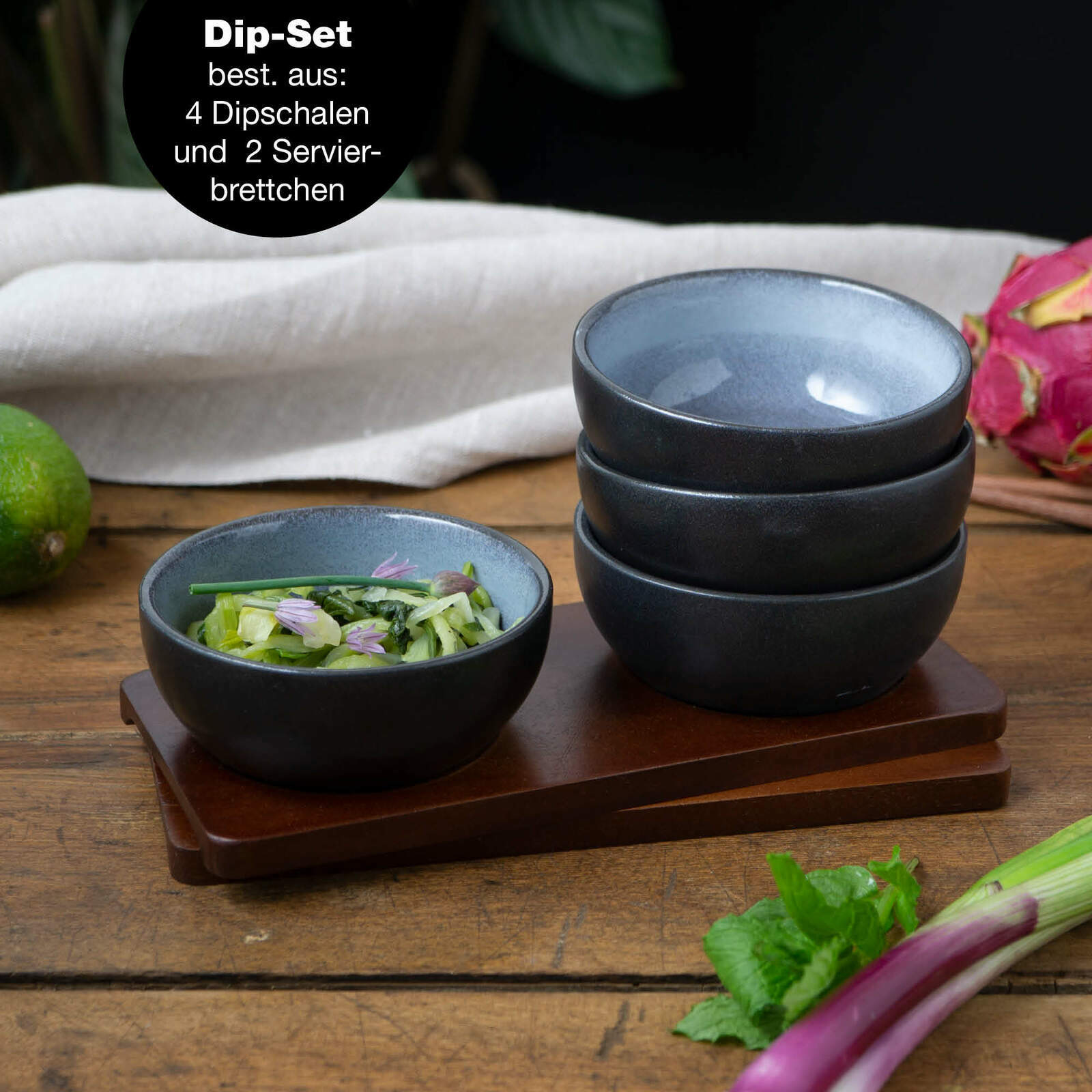 Perspektive: Frontalansicht auf ein Dip-Set bestehend aus vier blauen Schalen und zwei Servierbrettern, dekoriert mit frischen Zutaten.