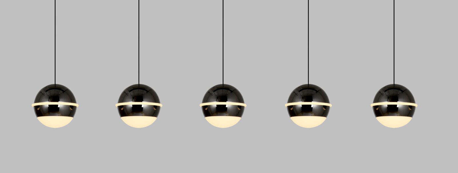 Vijf bolvormige LED-hanglampen in een rij, gefotografeerd vanaf de voorkant, met een glanzend zwart oppervlak en een verlichte onderkant.