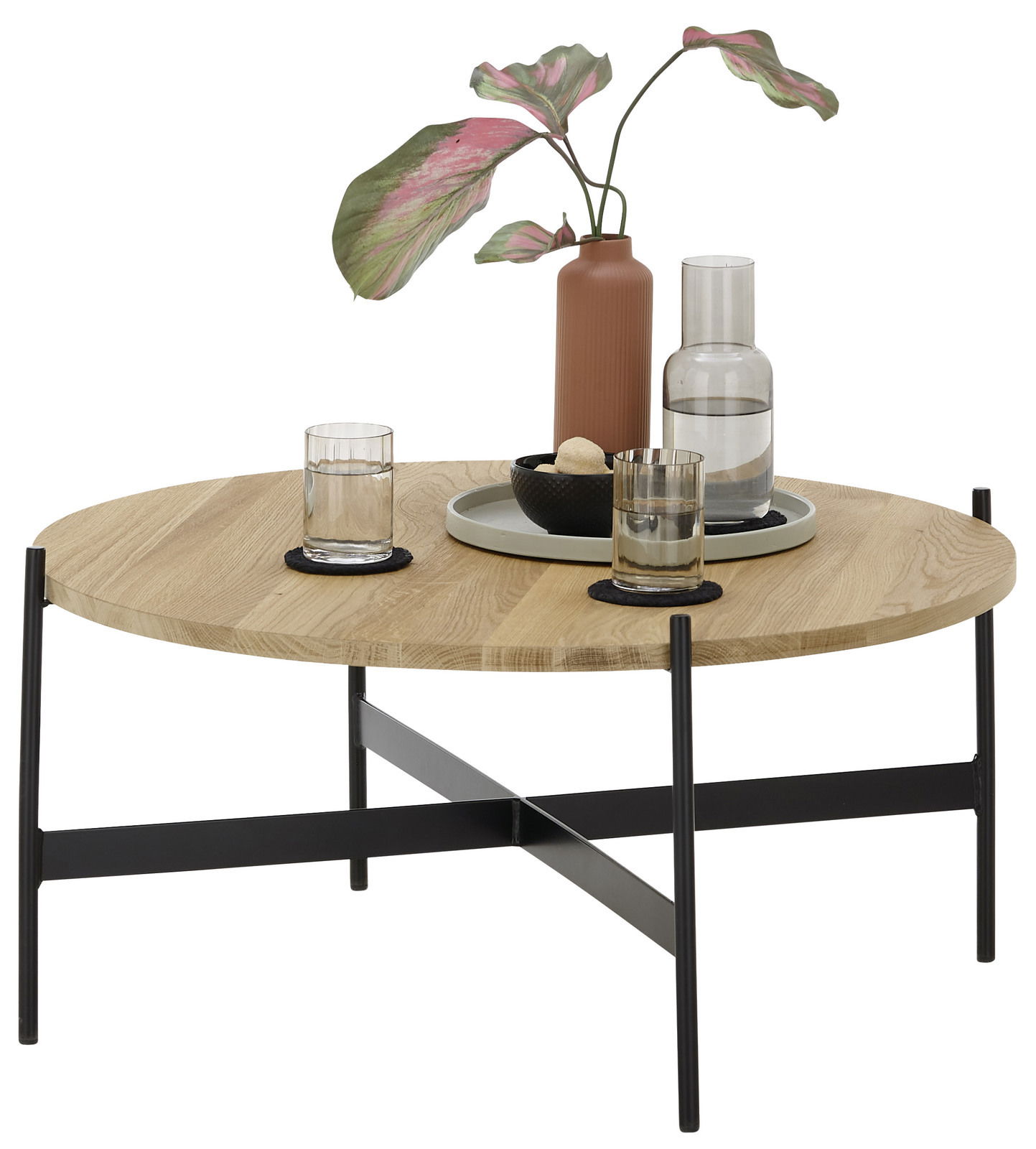 Set one by Musterring Couchtisch ORLANDO Runder Couchtisch mit Holzplatte und schwarzem Metallgestell, dekoriert mit einer Vase, Gläsern und einem Tablett, seitliche Perspektive