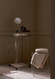 Luxuriöses Handtuch in einem stilvollen Badezimmer, auf einem transparenten Stuhl drapiert, mit elegantem Design und der Aufschrift 'JOOP!' in einer seitlichen Perspektive.