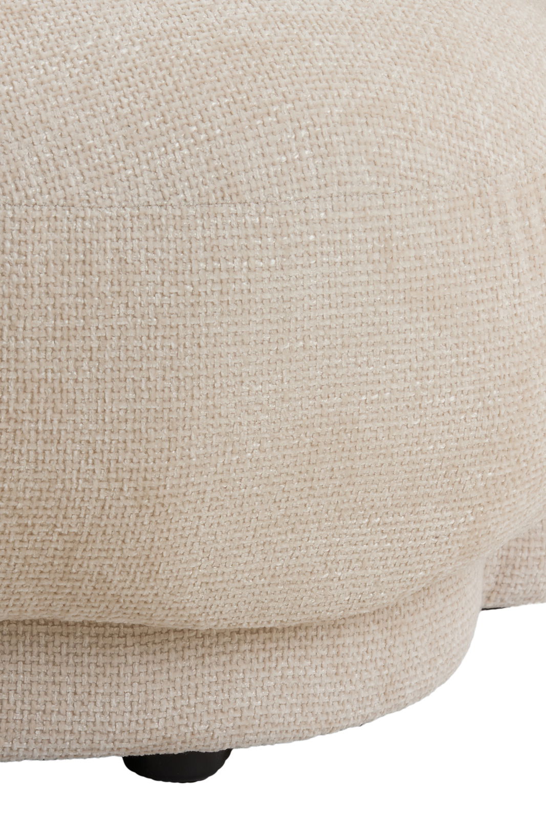 Nahaufnahme einer beigen Couch mit strukturierter Stoffoberfläche, seitliche Perspektive