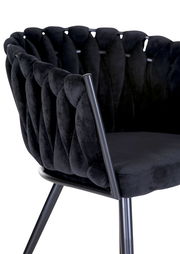 Nahaufnahme eines schwarzen Sessels mit gepolsterter Rückenlehne und Metallbeinen, seitliche Perspektive.