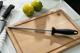 Wetzstahl 23cm mit schwarzem Griff auf einem Holzschneidebrett, seitliche Perspektive