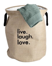 Wäschesammler aus natürlicher Jute mit schwarzem Schriftzug 'live. laugh. love.' und schwarzem Seilgriff, Vorderansicht.