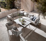 Moderne Loungegarnitur in einer eleganten Terrasse, bestehend aus einem Ecksofa, einem Tisch und zwei Stühlen, aus der Vogelperspektive fotografiert.