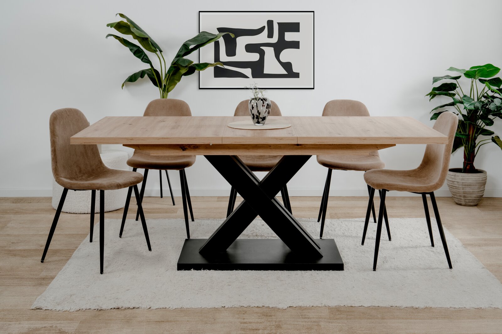 Moderner Esstisch mit Holzplatte und schwarzem X-förmigem Metallgestell, umgeben von sechs beigen Stühlen, aus der Frontalperspektive fotografiert.
