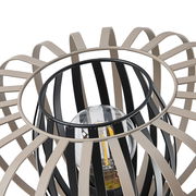 Nahaufnahme einer modernen Tischleuchte mit einem dekorativen, offenen Design aus schwarzen und beigen Streben, die eine Glühbirne umgeben. Perspektive von oben.