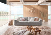 Großes, handgefertigtes Sofa in einem modernen Wohnzimmer mit Blick auf das Meer, frontal fotografiert.